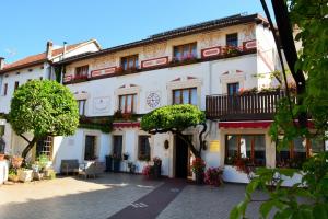 a white building with a balcony and tables and chairs at Alla Posta Guest House in Garna dʼAlpago
