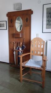 a wooden chair sitting in front of a wooden dresser at Atelierhaus Tannenweg in Worpswede