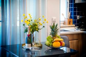 una mesa con un bol de fruta y un jarrón de flores en F&R Apartments II, en Rovinj