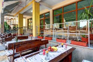 a restaurant with tables and benches and windows at Guest House Zara in Primorsko