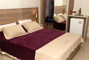 En eller flere senge i et værelse på Hotel Jabuticaba