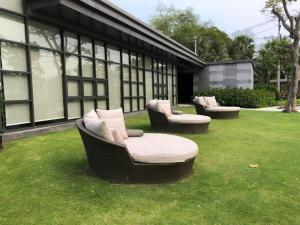 drei Sofas auf dem Rasen vor einem Gebäude in der Unterkunft เรนคอนโด ใกล้ ทะเลชะอำ-หัวหิน By Napatsogood in Cha-am