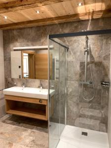 een badkamer met een wastafel en een douche bij Peil HighEnd-Basic apartments in San Candido