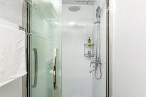 y baño con ducha y puerta de cristal. en Nancy Guesthouse en Shanghái