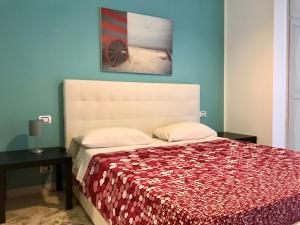 Schlafzimmer mit einem Bett mit einer roten Tagesdecke in der Unterkunft ROOM 110 BARI -guesthouse- in Bari