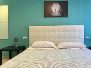 a bedroom with a white bed with a blue wall at ROOM 110 BARI -guesthouse- in Bari