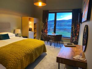 a hotel room with a bed and a table and a window at Stones Luxury B&B with hot tub and self-contained rooms in Uig