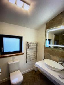 La salle de bains est pourvue d'un lavabo, de toilettes et d'un miroir. dans l'établissement Stones Luxury B&B with hot tub and self-contained rooms, à Uig