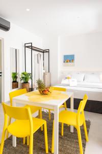 comedor con sillas amarillas, mesa y cama en Cozy Corner Luxury Apartments en La Canea