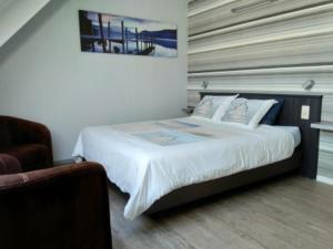 ein Schlafzimmer mit einem großen Bett und einem Stuhl in der Unterkunft B&B Hoeven Het Gehucht in Overpelt