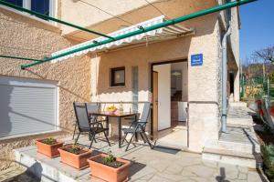 a patio with a table and chairs in front of a house at Horizont view apartment in Pula