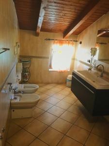 a bathroom with two toilets and a sink and a window at Agriturismo le tre stelle in Paestum +50 photos