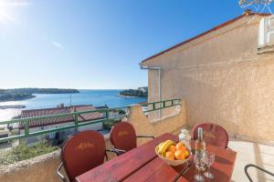 a wooden table with a bowl of fruit on a balcony at Horizont view apartment in Pula