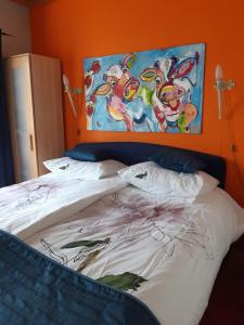 1 dormitorio con 1 cama con una pintura en la pared en Kitty's Place Warmond en Warmond