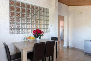 a dining room table with chairs and a vase of flowers on it at Horizont view apartment in Pula
