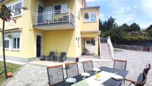un patio con mesa y sillas frente a una casa en Apartments Turan en Rijeka