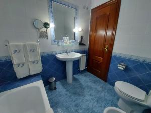 uma casa de banho azul com um WC e um lavatório em Posada El Jardin em Santillana del Mar
