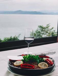 een bord eten en een glas wijn op een tafel bij Hotel Camping Lin in Pogradec