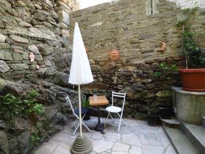 a patio with a table and an umbrella and chairs at appartamento da detta in Vernazza
