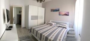 um quarto com uma cama e um armário branco em Apartment Batinica em Sibenik