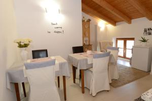 a dining room with a white table and chairs at Casa di Patrizia in Calavino