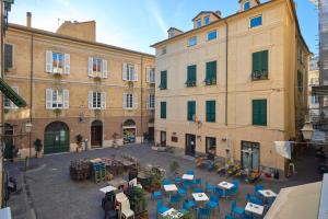 an empty courtyard with tables and chairs in front of buildings at A ca' de Lisetta in Albenga