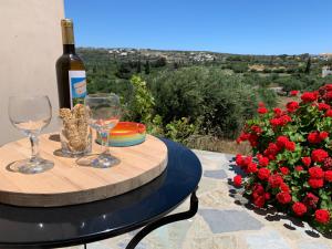 Una mesa con una botella de vino y dos copas. en Attik Residencies, en Livadi
