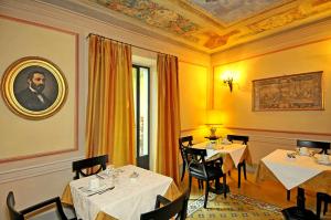 um restaurante com duas mesas e um retrato de um homem em Villa Lombardi em Camaiore