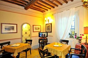 un comedor con 2 mesas y una ventana en Villa Lombardi en Camaiore