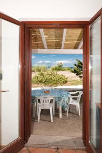 a glass door leading to a patio with a table and chairs at Stella Marina Budoni in Budoni