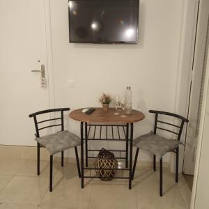 a table and two chairs with a table and a tv at DORA'S APARTMENTS STUDIO 1 in Corfu