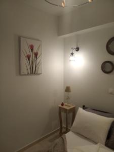 a bedroom with a bed and a picture on the wall at DORA'S APARTMENTS STUDIO 1 in Corfu