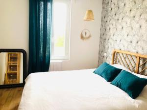 a bedroom with a white bed with blue pillows at Maison BB Burgonce Bohème centre avec extérieur WIFI gratuit et NETFLIX in Niort
