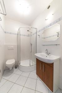 a bathroom with a shower and a sink and a toilet at Pokoje i Domki Atlantic in Jastrzębia Góra