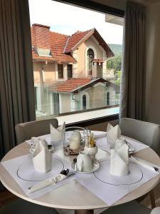 - une table blanche avec vue sur une grande fenêtre dans l'établissement Emerald Suites, à Flórina