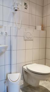 a bathroom with a toilet and a phone on the wall at China Restaurant Hotel Lotus in Rothenburg ob der Tauber