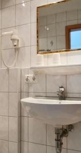 a bathroom with a white sink and a mirror at China Restaurant Hotel Lotus in Rothenburg ob der Tauber