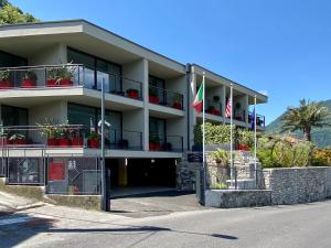 an apartment building with flags in front of it at Hotel Lago in Torno