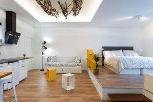 a bedroom with a king sized bed and a kitchen at Suite Nest in Padrón
