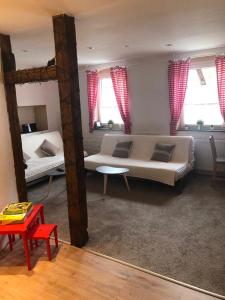 a bedroom with two beds and a table and windows at Haus Schönek in Warmensteinach