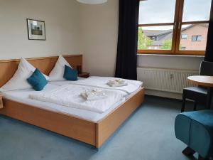 a bedroom with a bed with two plates on it at Olympia Hotel & Restaurant in Inden