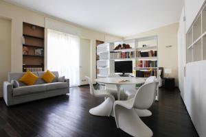 a living room with a table and chairs and a couch at Heart Milan Apartments San Sepolcro Duomo in Milan