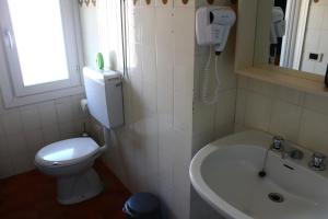 een badkamer met een toilet, een wastafel en een telefoon bij Albergo Del Lago in Bellano