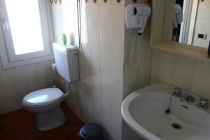 ベッラーノにあるAlbergo Del Lagoのバスルーム(トイレ、洗面台、電話付)