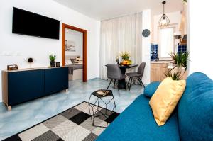 een woonkamer met een blauwe bank en een keuken bij F&R Apartments II in Rovinj