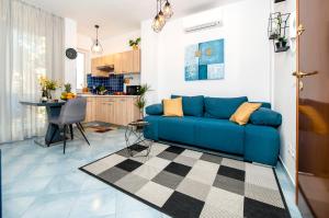 een blauwe bank in een woonkamer met een keuken bij F&R Apartments II in Rovinj