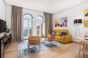OLA Opatija Luxury Apartments في أوباتيا: غرفة معيشة مع أريكة صفراء وطاولة
