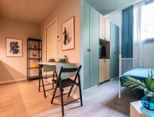 ミラノにあるThe Suite Spotのベッド、テーブル、椅子が備わる客室です。