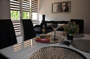 a table with a bottle of wine and a glass at Apartament DeLuxe 1 in Oświęcim
