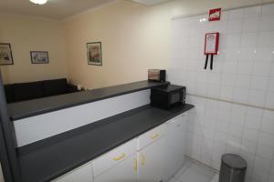 una sala de espera con barra y microondas en ApartamentoSolPraia - VilaRosa, en Portimão
